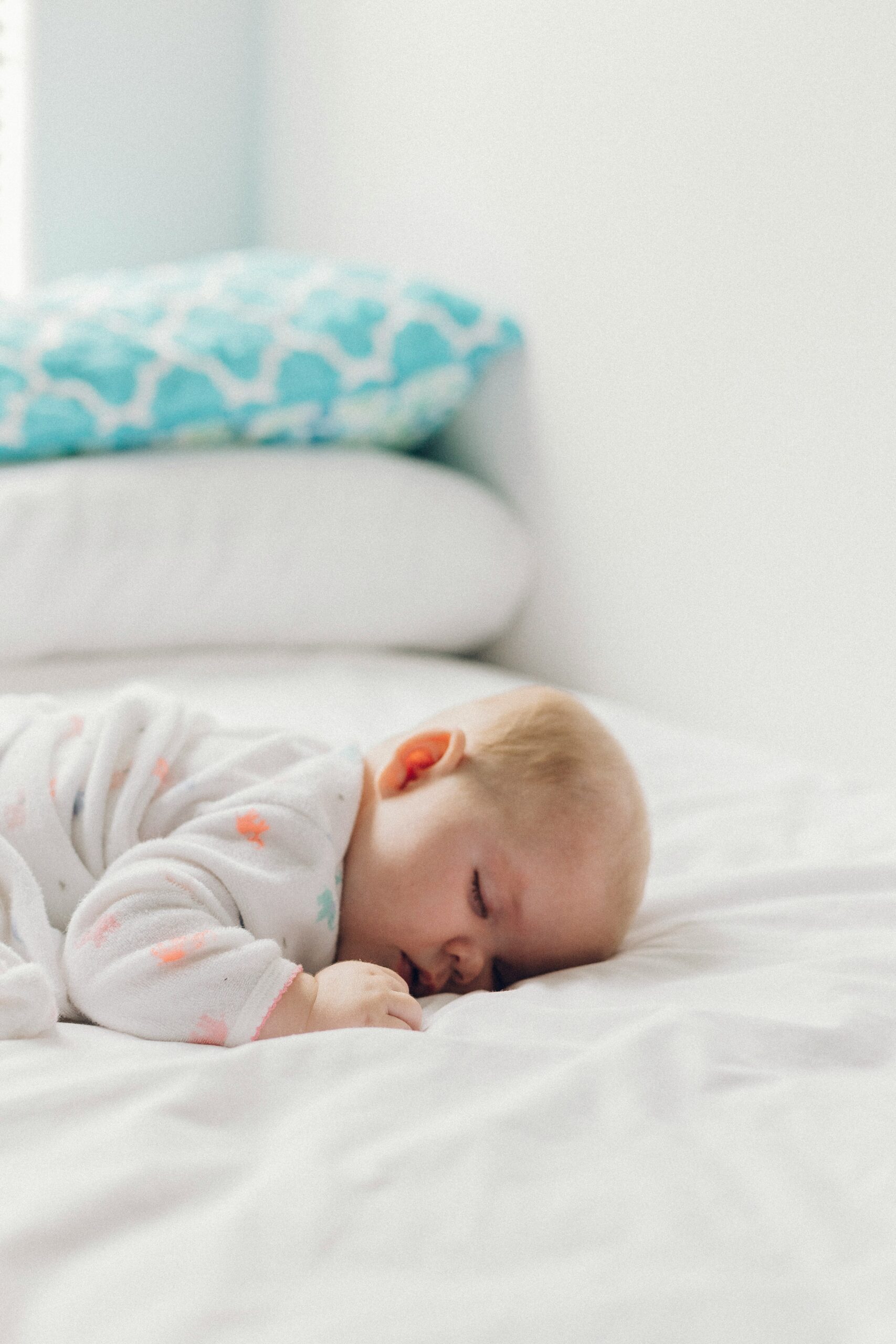 baby sleeping on bed belly down