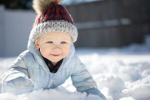 Baby wearing hat playing in snow
