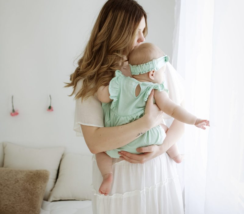 women holding baby looking out window